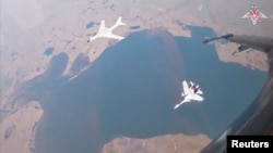 俄罗斯国防部2024年7月25日公布的视频截图显示,中国人民解放军空军一架H-6K轰炸机在俄罗斯苏霍伊Su-30CM喷气式战斗机的伴随下,在美国阿拉斯加州附近进行中俄军机联合巡逻。