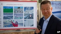 资料照:中国政府组织外国记者参观新疆维吾尔自治区阿克苏期间,新疆华孚色纺集团有限公司总经理李强在其公司宣传板前讲话。(2021年4月20日)