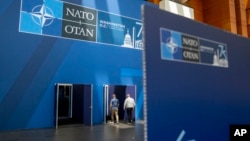 人们走在沃尔特·E·华盛顿会议中心内部,该中心已经装饰上标志,为北约峰会做准备。(2024年7月8日)