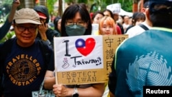 台湾民众聚集在台北的立法院外,一名女子手举支持台湾的标语。(2024年5月24日)