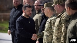 资料照片:乌克兰总统新闻处2024年3月31日公布的照片显示乌克兰总统泽连斯基在布查镇举行的一次纪念俄罗斯入侵受害者的活动期间与乌克兰武装部队总司令西尔斯基将军握手。