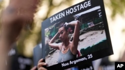 在伦敦的英国首相官邸唐宁街10号外举行支持以色列的集会上,一人手举一名25岁的以色列姑娘被巴勒斯坦武装分子劫为人质的照片。(2023年10月9日)