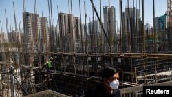 资料照:一名男子在北京一个地铁站施工现场附近的天桥上行走。(2023年4月18日)