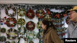 资料照:2023年12月14日,人们走过北京一家商场的圣诞装饰。(路透社)