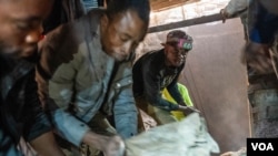 刚果民主共和国东南部科卢韦齐附近的卡米隆贝矿井中,工人们正在从矿井中搬运一袋袋矿石。 (2023年6月20日)