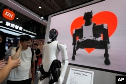 资料照:北京举办的世界机器人大会小米展台上展示的机器人和机器狗图像。(2023年8月16日)