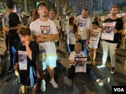 原本在广场上与群众一起等待会议报告的人质家属逐渐失去耐心、开始发声抗议,由广场转移阵地到街道上中断交通。当警察尝试恢复交通秩序,一位人质(Jonathan Samerano)的祖母干脆坐在街道上、手拿孙子的海报、带领群众呐喊“现在就交换他们”。(美国之音/赖素芬)