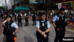 资料照片:2023年6月4日,1989年北京天安门广场镇压34周年之际,中国香港警察在市中心待命,附近是以往通常举行烛光守夜活动的场所。
近日,警方和大学当局阻止学生举行纪念雨伞运动的守夜活动,甚至在10月1日逮捕了一名在公共场合手持白花的男子。(路透社图片)