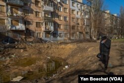 赫尔松一处公寓楼群落的大弹坑。(2023年1月26日,美国之音博夏特拍摄)