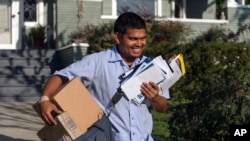 资料照片:2024年3月22日,美国邮局邮递员加布里埃尔·佩尼亚在洛杉矶投送邮件。(美联社照片)