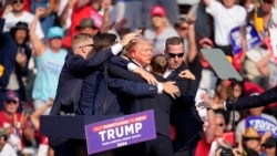 在宾夕法尼亚州的一次竞选集会发生枪击事件,安全人员帮助受伤的共和党总统候选人、前总统特朗普离开讲台。(2024年7月13日)