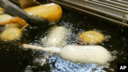 资料照片:2007年8月8日,在美国印第安纳波利斯市举办的印第安纳州博览会的食品摊位上,正在使用不含反式脂肪的油煎炸糖果。(美联社照片)