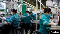 2022年2月17日,中国北京施耐德电气工厂的员工在生产线上工作。