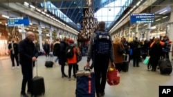 2023年12月22日,旅客在伦敦圣潘克拉斯车站排队等候欧洲之星列车。(美联社照片)