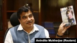Menteri Transportasi dan Perkapalan India Nitin Gadkari memamerkan buku yang ditulisnya di kantornya di New Delhi, India, 26 Agustus 2015. (Foto: REUTERS/Anindito Mukherjee)