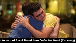 穿着黄色印有“国家地理杂志”字样的T恤的吉尔·哈祖特(Gil Hazut)，哈马斯袭击的幸存者，忍不住在古特曼的拥抱中失声痛哭。（照片受访者提供）