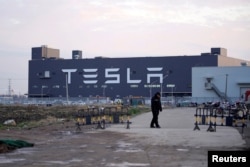 资料照：一名保安守卫在特斯拉上海超级工厂外。 （2020年1月7日）