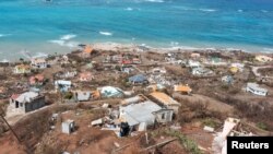 Puing-puing berserakan dan rumah-rumah dengan atap yang hilang akibat hantaman Badai Beryl di pulau Petite Martinique, Grenada 2 Juli 2024. (REUTERS/Arthur Daniel)