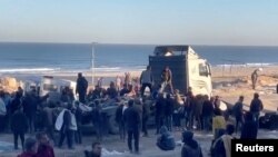 在以色列2024年2月29日据称向加沙市等待援助的人们开火后,巴勒斯坦人正在运送伤亡人员。