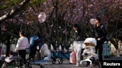 上海一个公园里父母推着婴儿车赏春。(2023年4月2日)