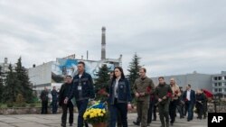 乌克兰切尔诺贝利核电站的工作人员向切尔诺贝利核事故罹难者纪念碑献花。(2023年4月26日)