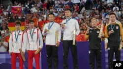 来自台湾的李洋和王齐麟站在2024巴黎奥运会羽毛球男双金牌领奖台上。(2024年8月4日)