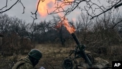 乌克兰军人在巴赫穆特附近向俄罗斯阵地炮击。(2023年3月11日)