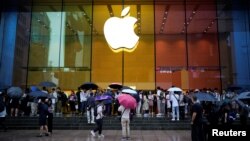 资料照片:上海一家苹果专卖店外排队的人等候购买iPhone15手机。(2023年6月15日)