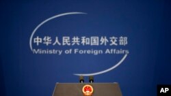 资料照片——2015年11月19日，中国北京外交部办公室每日简报前，可以看到带有中华人民共和国国徽和中国外交部标志的讲台。