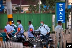 在北京一处市场执勤的警察和城管。(2020年6月12日)