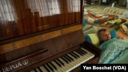 斯韦特兰娜的丈夫米沙躺在康斯坦丁尼夫卡一处庇护所的床上。他几年前中风,随时需要照顾。(2023年4月11日,美国之音博夏特拍摄)