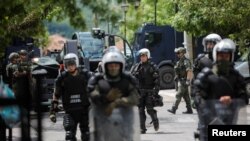 科索沃维和部队的波兰军人在科索沃兹韦钱镇市政办公室前警戒。(2023年5月30日)