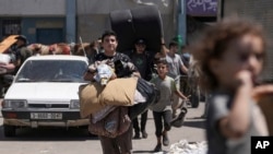 2024年8月16日,巴勒斯坦人撤离加沙地带东部的一所学校,该学校曾是他们的避难所,此前以色列军方投下传单,要求平民从该地段撤离。(美联社照片)