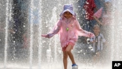 一个小女孩在北京一家商场的喷水池玩水。(2023年6月23日)