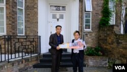 “29原则”执行总监叶七轮(Chakra Ip,右)代表85个人权组织将联署信递交老挝驻英国大使馆职员。(美国之音/郑乐捷)