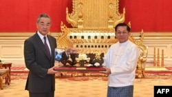 资料照片:2024年8月14日,缅甸军政府领导人敏昂莱(右)在内比都与中国外交部长王毅会晤。(法新社照片)