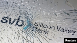 路透社资料照 - 一块被打碎的玻璃下隐约可见硅谷银行的英文招牌。