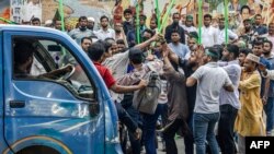 资料照片:孟加拉国抗议民众在首都达卡包围一名前总理哈西娜的同情人士。(2024年8月15日)