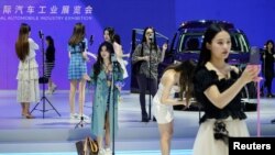 资料照:上海汽车展上销售人员在直播带货。(2022年4月19日)