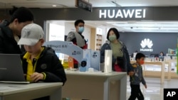 资料照:顾客正在北京一家商场的华为商店参加华为产品。(2023年4月28日)