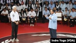 Calon presiden Prabowo Subianto (kanan) menanggapi pertanyaan calon presiden Ganjar Pranowo (kiri) dalam debat pertama Capres 2024 yang diadakan oleh KPU pada Selasa (12/12) di Jakarta. (VOA/Indra Yoga)