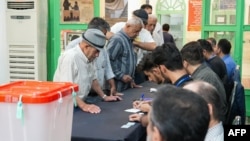 伊朗男子在德黑兰西南部的一个投票站准备在伊朗总统决选中投票。(2024年7月5日)