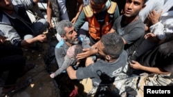 巴勒斯坦民众在加沙中部努塞拉特难民营的废墟下找到一具死亡儿童的尸体。(2024年5月14日)