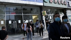 资料照:寻找工作的人在北京郊区的一个招聘站外等待。(2020年5月13日)