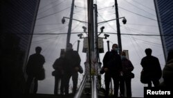 人们行走在装有监控摄像头的上海街头。(2022年12月12日)