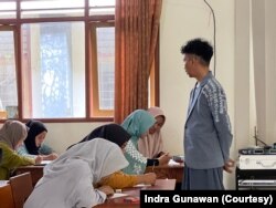 Indra mengajar di kelas dengan memakai baju berdesain unik, kadang dia membeli karya siswa untuk memacu kreativitas mereka. (Foto: Courtesy/Indra G)