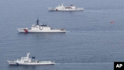 2024年6月6日,日本海上保安厅提供的这张照片显示,日本海上保安厅的巡逻舰“若狭号”(自下而上)、美国海岸警卫队的巡逻舰“韦舍山号”和韩国海洋警察厅的巡逻舰“泰平壤 16 号”以及一架飞行中的直升机(红色)在日本舞鹤北部海岸附近海域参加演习。(美联社照片)