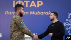 2023 年4月7日,在乌克兰基辅郊外的一个伊斯兰中心举行的庆祝伊斯兰斋月的开斋晚宴前,乌克兰总统泽连斯基(右)向一名穆斯林军人颁奖。