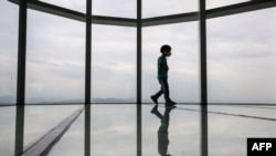 一个孩子走在韩国首尔乐天世界塔123层高的观景台玻璃地板上。(2022年5月13日)