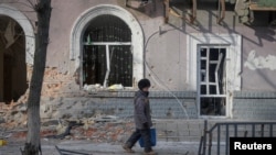 资料照片:当地居民走在乌克兰前线城镇巴赫穆特的空荡街道上。(2023年2月24日)